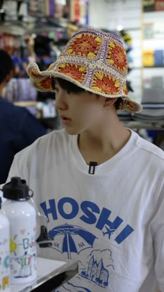 a young man wearing a hat while sitting at a table