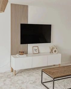 a flat screen tv sitting on top of a white entertainment center in a living room