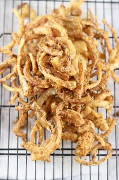 fried onion rings on a cooling rack ready to be cooked in the oven or used as an appetizer