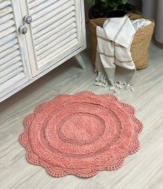 a pink rug on the floor next to a cabinet