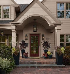 the front entrance to a house with potted plants