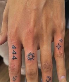 two people with tattoos on their fingers, one has a sun and the other has an arrow