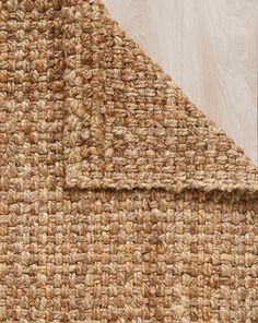 a close up view of a rug on the floor with wood in the back ground