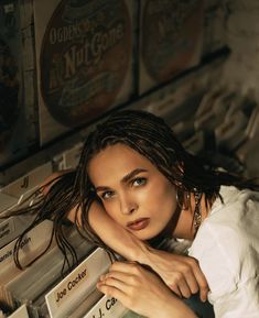 a woman with dreadlocks is leaning on a shelf in front of some records