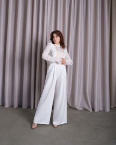 Be the center of attention in this white jumpsuit designed to make you the center of attention. Don't miss the opportunity to flaunt this incredibly elegant piece that is as versatile as it is chic. This white long sleeve wedding jumpsuit is an indispensable fashion item for any woman who seeks style, comfort and sophistication. The fitted cut accentuates your curves, while the white wedding jumpsuit offers a refreshing alternative to traditional gowns. Thanks to the exquisite Italian lace, it c Lace Long Sleeve Jumpsuits And Rompers For Party, Elegant White Long Sleeve Jumpsuit, Elegant Jumpsuit With Sheer Long Sleeves, White Long Sleeve Jumpsuits For Evening, White Long Sleeve Jumpsuits And Rompers For Evening, White Full-length Evening Pants, Elegant Long Sleeve Lace Jumpsuits And Rompers, Lace Jumpsuits And Rompers For Wedding, Chic Long Sleeve Jumpsuit For Wedding