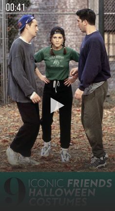 two men and a woman standing next to each other in front of a chain link fence