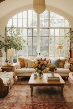 a living room filled with lots of furniture and flowers on top of a coffee table