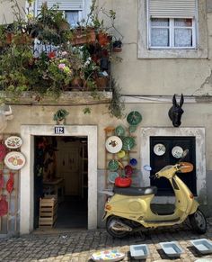 a scooter parked in front of a building with plates on the ground