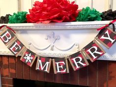 a christmas banner hanging from the mantle above a fire place with poinsettis