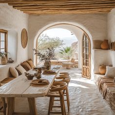 an arched doorway leads to a dining room with seating and table set for six people