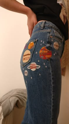 a person wearing jeans with planets on them