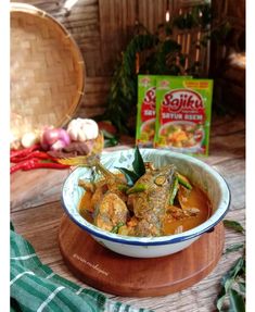 a bowl filled with food sitting on top of a wooden table next to a bag of rice