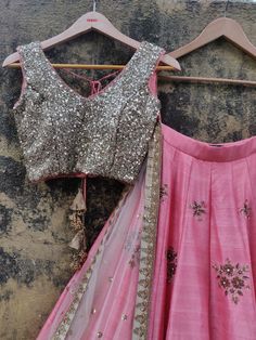 This peach raw silk lehenga with sequin, stone and zardosi hand embroidery is paired with a gold sequin work blouse.  The outfit is completed with a nude net dupatta. Pink Tissue Silk Choli With Mirror Work, Pink Tissue Silk Choli With Gota Work, Pink Choli With Gota Work In Tissue Silk, Gold Embellished Chanderi Lehenga, Gold Embellished Dola Silk Lehenga, Gold Embellished Lehenga In Dola Silk, Embellished Semi-stitched Raw Silk Lehenga, Wedding Lehenga In Raw Silk With Sequins, Wedding Lehenga With Sequins In Raw Silk