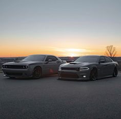 two cars parked next to each other in front of the sun