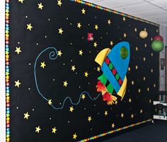 a bulletin board with a rocket ship painted on it's side and stars in the background