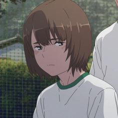 an anime character with brown hair and blue eyes standing in front of a tennis court