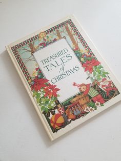 a book with the title'treasures tales of christmas'written in green and red