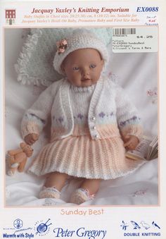 a baby doll wearing a knitted outfit and holding a book