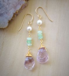 These raw Amethyst, Chrysoprase, & Freshwater Pearl earrings are the perfect accessory to bring your look to the next level - and possibly bring you some healing properties, too! Long and playful, they come in your choice of Sterling Silver or 14k Gold Filled. Amethyst, the birthstone for February, is believed to carry the energies of passion, creativity, and spirituality. It's also said to assist with temperance and sobriety, as well as inflammation. Chrysoprase, also known as green Chalcedony, Gem Stone Earrings, Ear Art, Wire Wrapped Jewelry Tutorials, Unique Handcrafted Jewelry, Natural Gemstone Necklace, Green Chalcedony, Silver Earrings Handmade, Raw Amethyst, Long Dangle Earrings