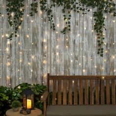 a wooden bench sitting next to a wall covered in lights