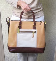 This Coach color block tote is in MINT condition!  Smooth tan leather with cream colored front pocket and Brown leather bottom, top handles and shoulder strap.  Large enough for a small laptop and more.  Zip top with large interior compartment.  Tan twill interior with side zip and cell phone pockets.  Gold colored hardware. Coach Color Block Purse, Color Block Tote, Small Laptop, Zip Top, Tan Brown, Laptop Bag, Tan Leather, Cream Color, Purses And Handbags