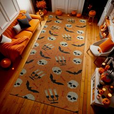 a living room decorated for halloween with pumpkins and skulls on the rug, candles and decorations