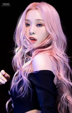 a woman with long pink hair is posing for the camera