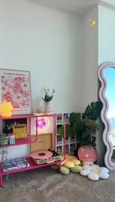 there is a pink shelf with various items on it and a mirror in the corner