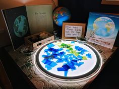 a table topped with lots of different types of paper and framed pictures on top of it