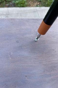 a close up of a pen on top of a wooden table with grass in the background