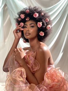 a woman with flowers in her hair sitting on a bed and posing for the camera