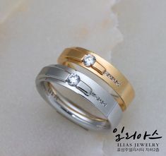 two gold and silver wedding rings with diamonds on each one, set against a white background