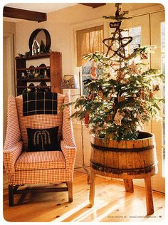 a living room with a christmas tree in the corner and an old fashioned chair next to it