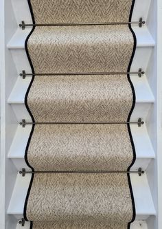 a carpeted stair case with white trim and black piping on the bottom part