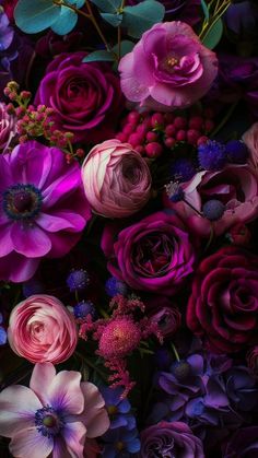 a bunch of flowers that are in some kind of vase on a table with purple and pink colors