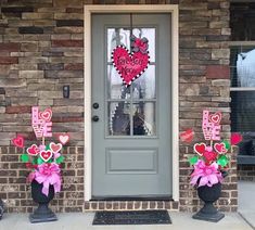 two vases with hearts on them are outside the front door to a house that has been decorated for valentine's day