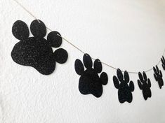 a black and white dog paw print banner hanging from a line of clothes pins on a wall