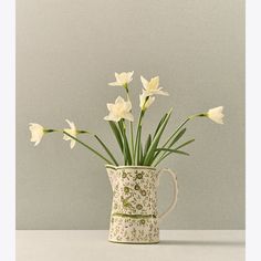 some white flowers are in a vase on a table