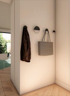 a coat rack with two coats hanging on it next to a bag and hat hanger