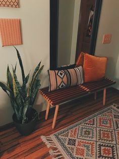 a wooden bench sitting in front of a mirror on top of a hard wood floor