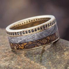 two rings sitting on top of a rock next to each other and one is made out of wood