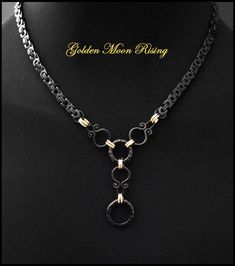 My Golden Moon Rising necklace features a flat black finish byzantine design stainless steel chain with geometric shapes and lustrous gold connector rings and drop chain. The chain can be ordered in a collar or necklace length in 1-inch increments from 14 to 26 inches. It will surely get admiring looks and start conversations wherever you wear it.  The necklace comes with my signed certificate of authenticity, a deluxe gift box, and a velvet jewelry pouch. The chain is a durable black ion-plated Black Spiritual Chain Necklace, Symbolic Moon Shaped Metal Necklace, Black Crescent Metal Necklace, Gold-plated Crescent Necklace With Adjustable Chain, Byzantine Design, Moon-shaped Metal Necklace With Adjustable Chain, Golden Moon, Byzantine Chain, Moon Rising