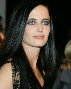 a woman with long black hair and blue eyes posing for the camera at an event