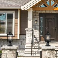 the front door of a house with two lanterns on it's steps and stairs