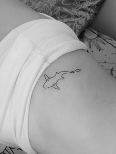 a black and white photo of a woman's stomach with a tattoo on it