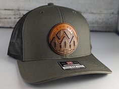 Mountain wood on leather patch hat.  Through a painstaking process we have learned how to inlay wood and leather for a one-of-a-kind style hat. Impress your friends with the mountain landscape patch hat.  As always made on high quality snapback hat. -Product Care instructions-                      Hand wash only.   -Shipping and Production-                     We produce each item as made to order.  Currently our production and shipping time is 1-3 business days.  We also can ship            pri Brown Hats With Leather Patch For Outdoor Activities, Leather Hat Pattern, Laser Cut Fashion, Womans Hat, Leather Patch Hat, Patch Hat, Unique Hats, Hat Patches, Man Hat