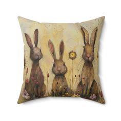 three rabbits sitting in the grass on a pillow