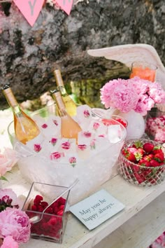 pink flowers and wine bottles on a table