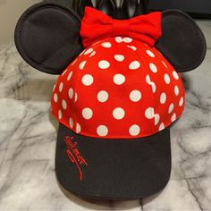 Authentic Merchandise Made Exclusively For Sale At Disneyland Top Your Day At The Happiest Place On Earth W/ Minnie's Polka Dot Baseball Cap Trimmed In Her Trademark Ears & Bow, Plus Embroidered ''Signature'' Accent On The Brim Of The Hat In Minnie's Bright Red Color Baseball Cap W/ Mouse Ears & Bow Embroidered Minnie Mouse ''Signature'' On Bill Embroidered Classic Disneyland Logo On Back Polka Dot Print Canvas Body Adjustable Snapback Strap For Secure Fit One Size Fits Most Girls Adjustable Minnie Mouse Cap, Fun Mickey Mouse Themed Hat One Size Fits Most, Adjustable Mickey Mouse Fun Hat, Fun Mickey Mouse Hat, Red Mickey Mouse Adjustable Hat, Adjustable Red Mickey Mouse Hat, Black Adjustable Minnie Mouse Hat, Adjustable Black Minnie Mouse Hat, Black Mickey Mouse Cap