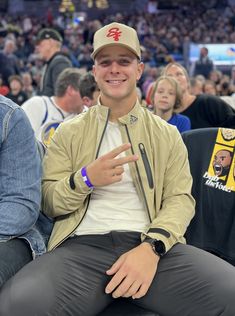 a man sitting on top of a chair at a basketball game